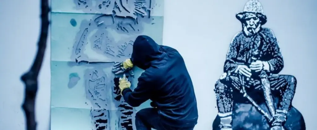 An street artist using spray for stencil